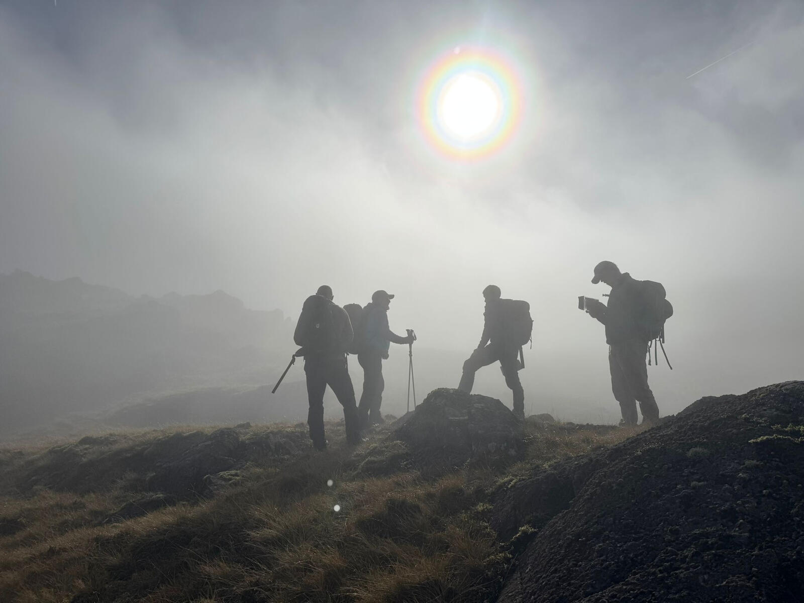 Mountain Leader Image of people map reading on a foggy mountain